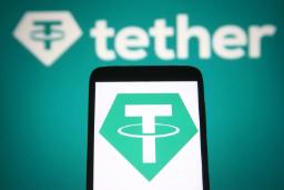 لوگوی ارز دیجیتال تتر (Tether) روی صفحه نمایش گوشی هوشمند