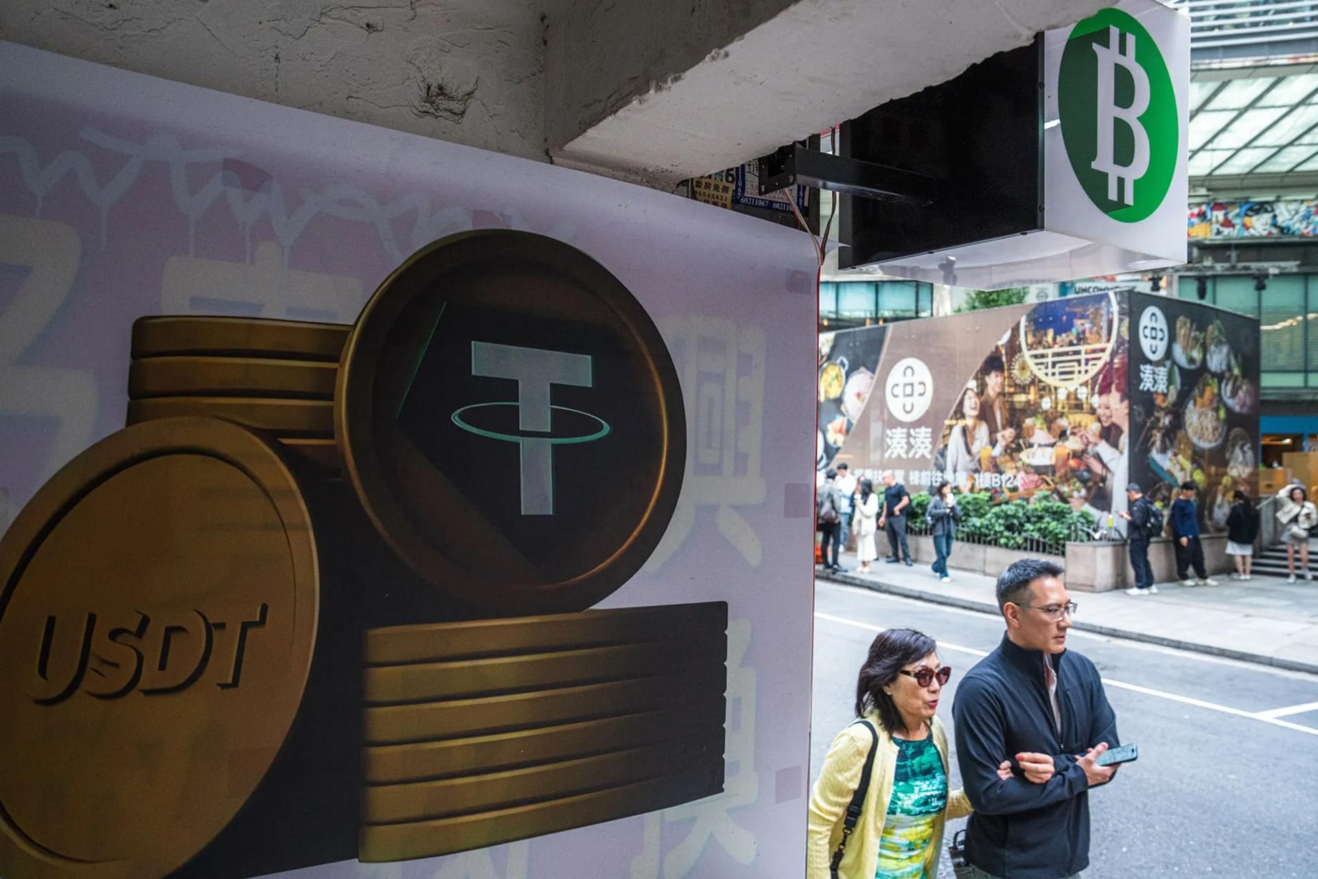 نمادهای سکه‌های دیجیتال تتر (Tether) و بیت‌کوین (Bitcoin) در فضای شهری