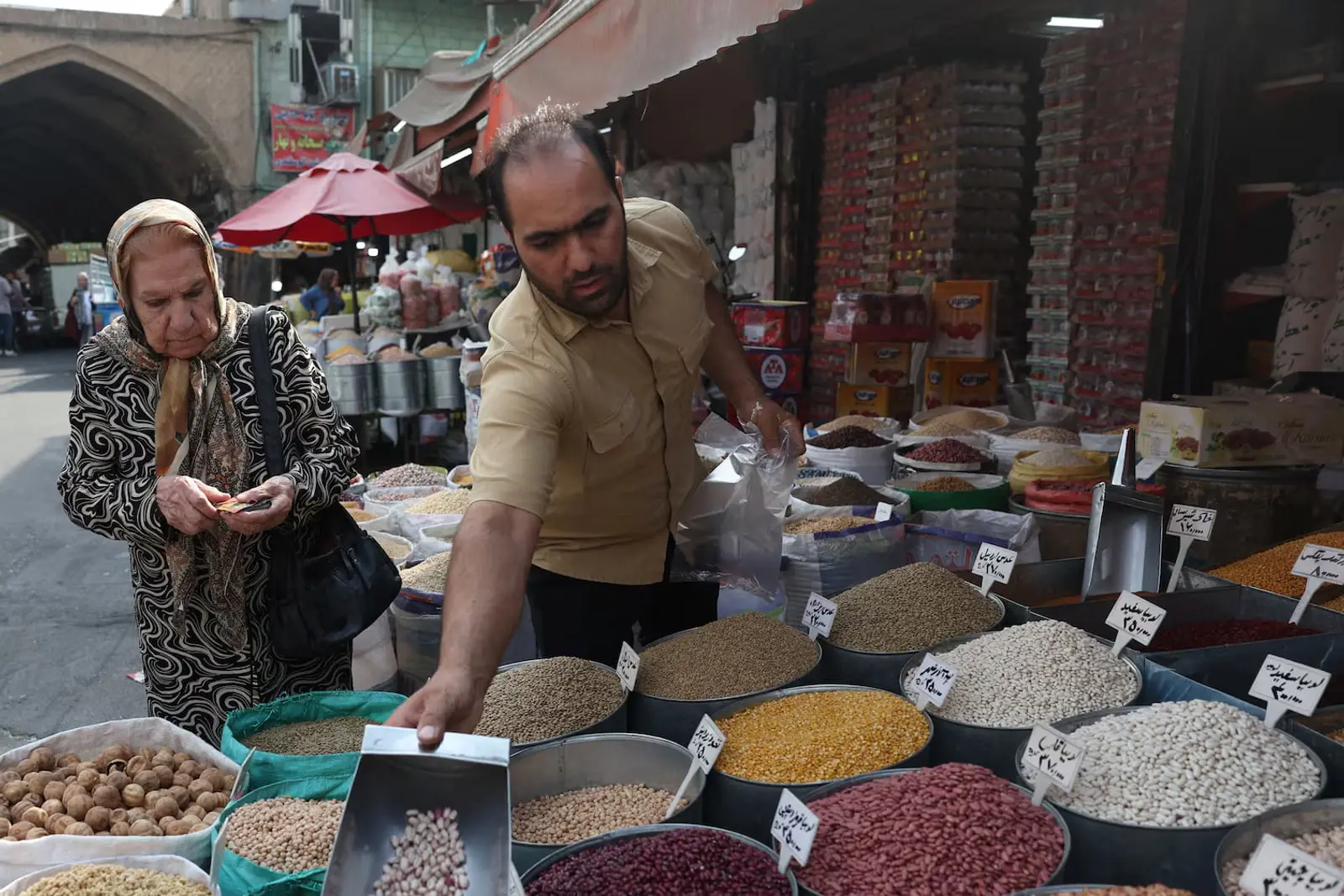 خرید انواع حبوبات و خشکبار توسط مشتری در یک بازار سنتی