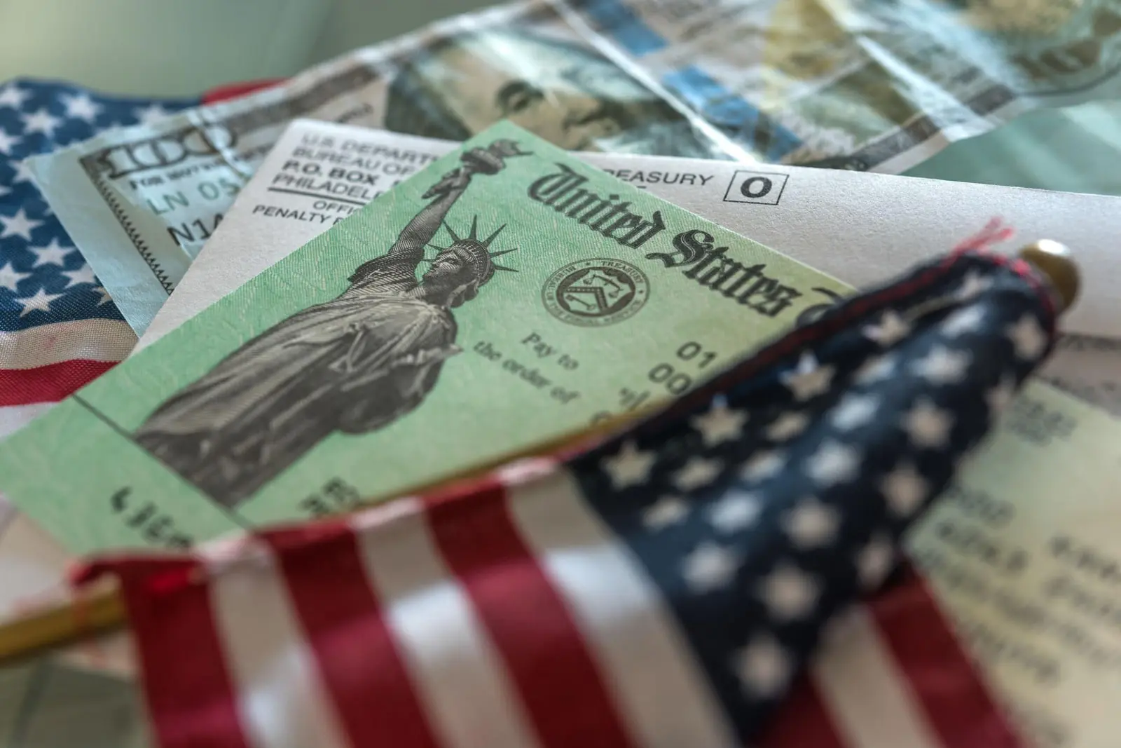 چک‌های دولتی ایالات متحده (United States) در کنار پرچم آمریکا