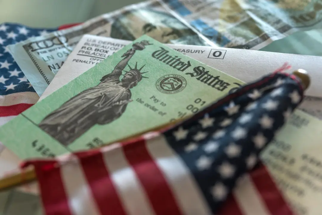 چک‌های دولتی ایالات متحده (United States) در کنار پرچم کوچک آمریکا