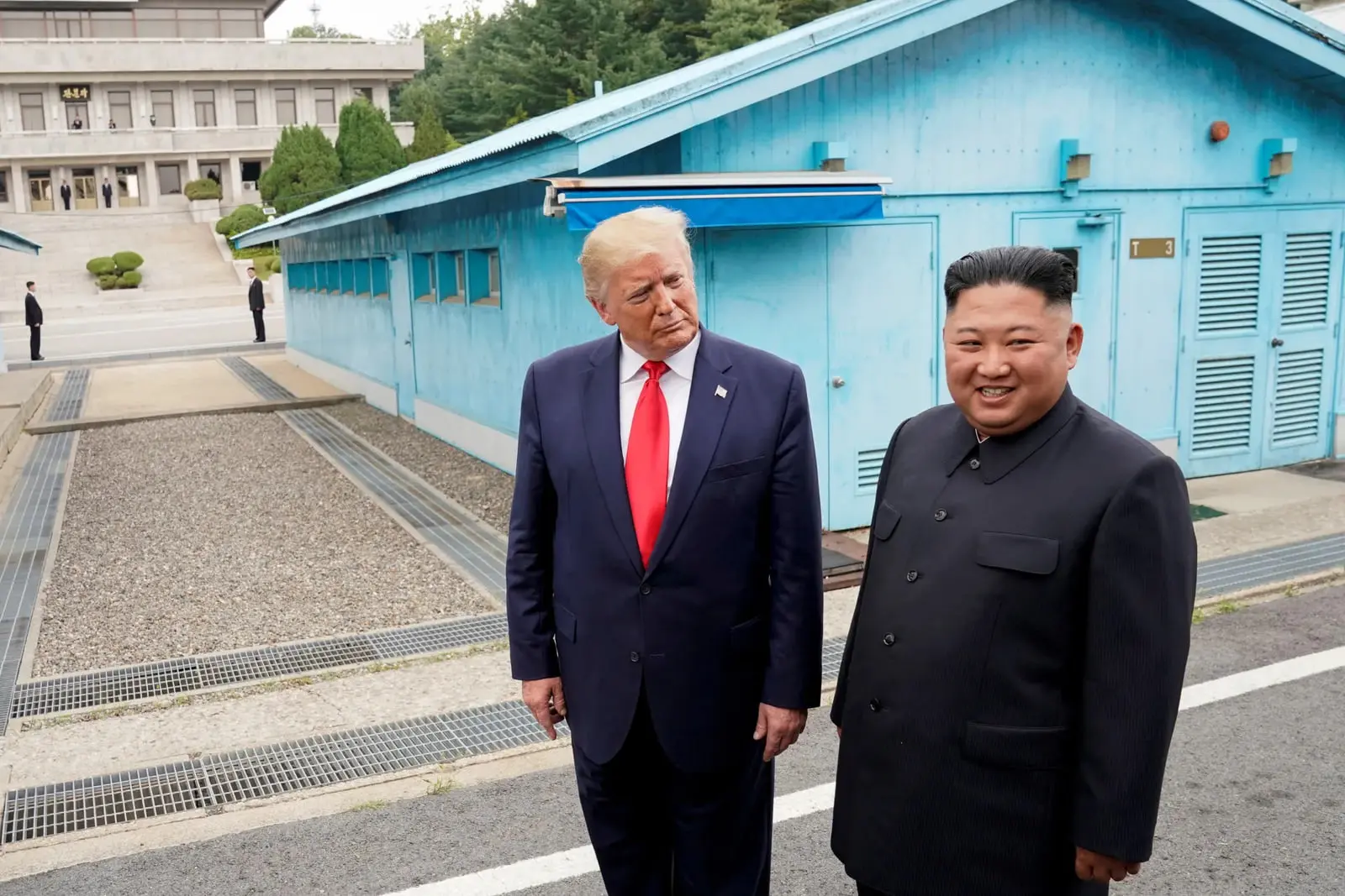 دونالد ترامپ (Donald Trump) و کیم جونگ اون (Kim Jong Un) در مقابل ساختمان‌های آبی در مرز کره