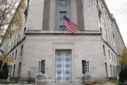 نمای ساختمان وزارت دادگستری ایالات متحده آمریکا (United States Department of Justice) با پرچم آمریکا