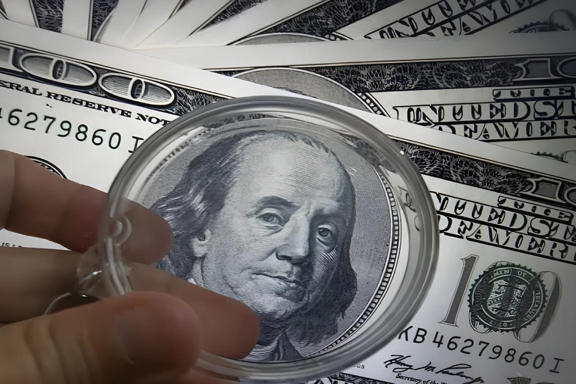 صورت بنجامین فرانکلین (Benjamin Franklin) روی اسکناس ۱۰۰ دلاری زیر ذره‌بین