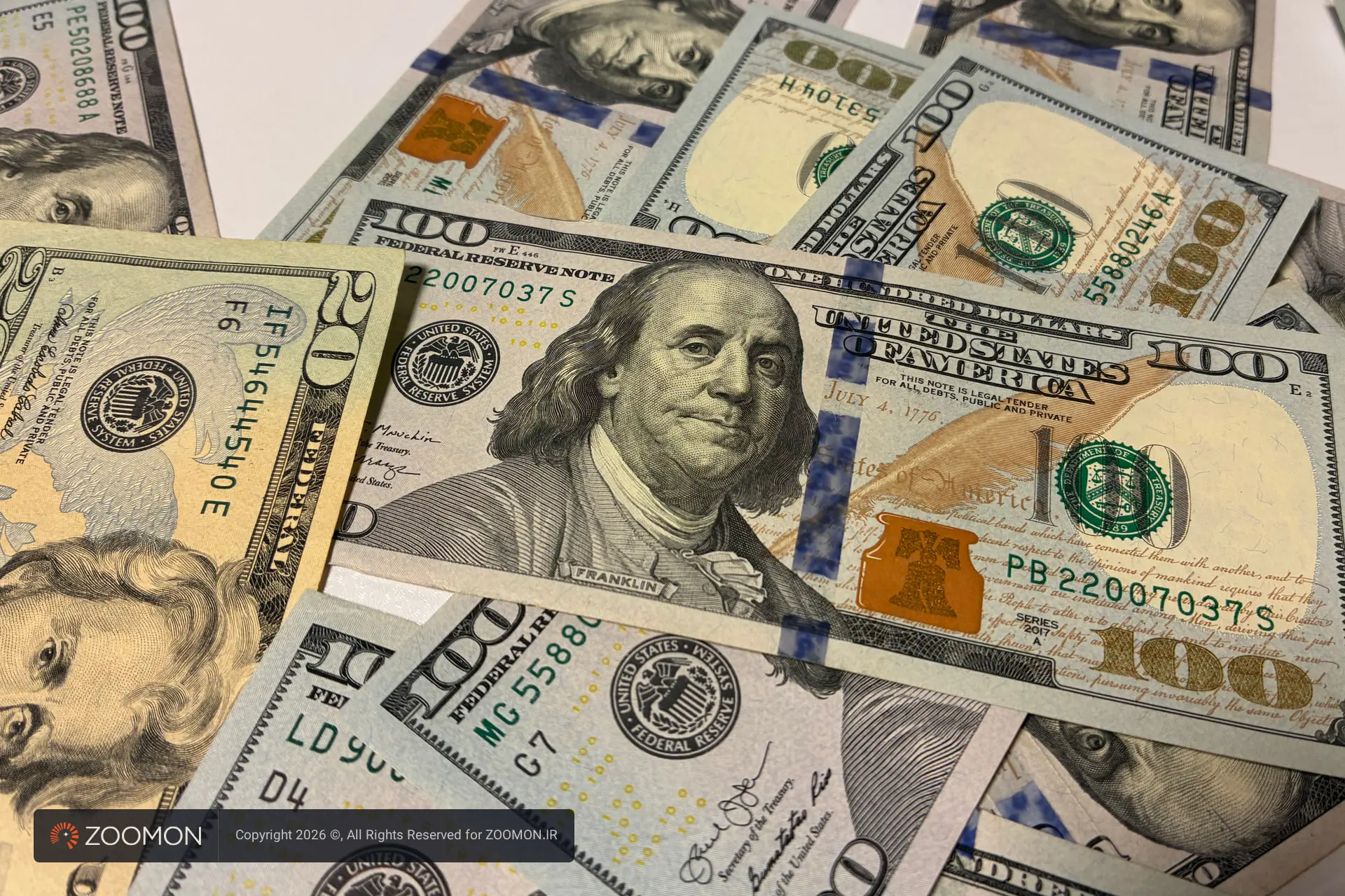 اسکناس‌های متنوع دلار آمریکا (US Dollar) با denominations مختلف روی سطح سفید