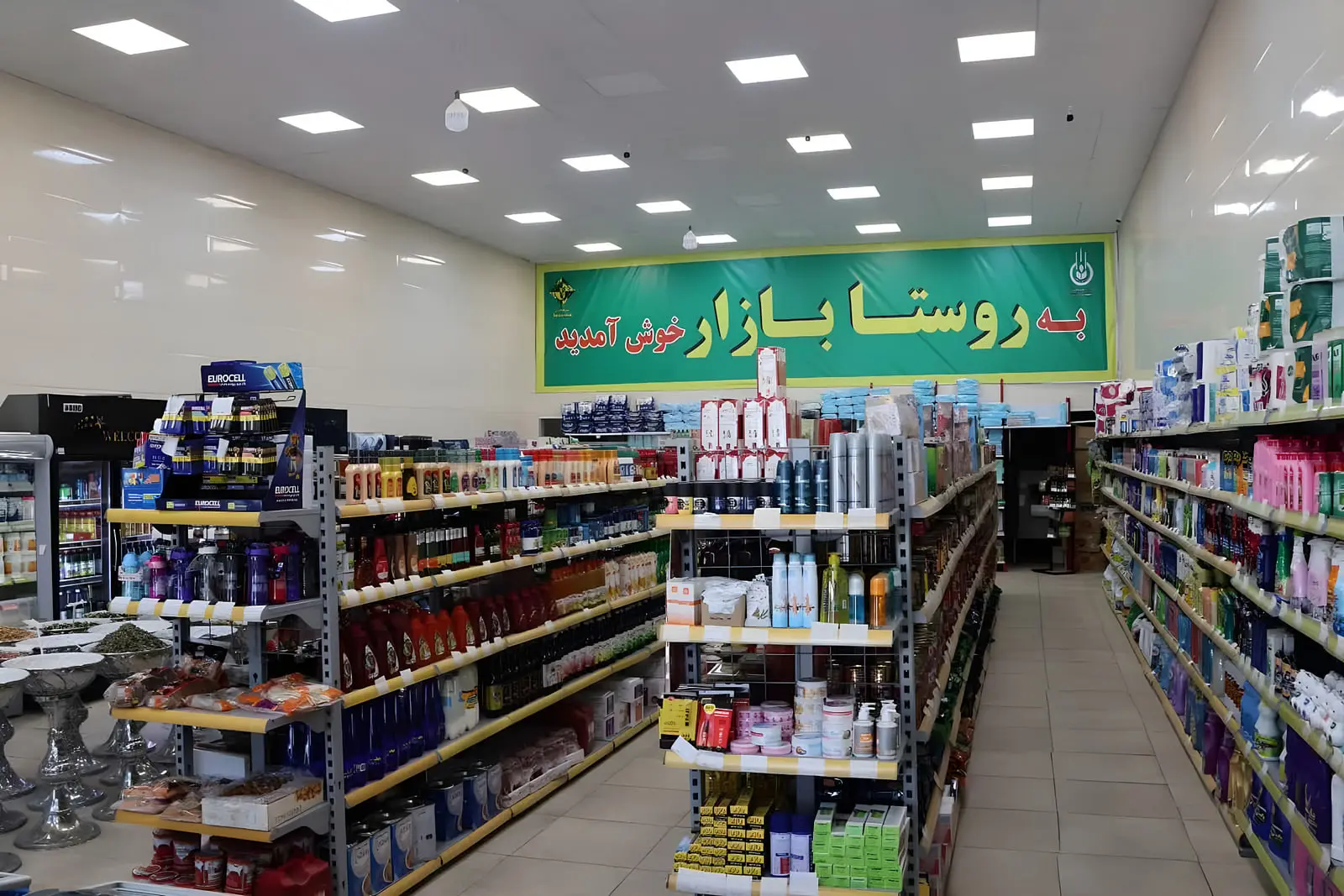 قفسه‌های پر از کالاهای مصرفی در یک فروشگاه محلی در روستا