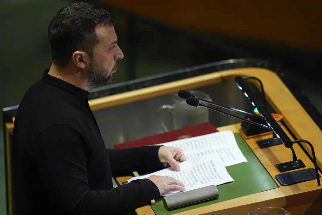 ولودیمیر زلنسکی (Volodymyr Zelenskyy) در حال مطالعه متن سخنرانی پشت تریبون